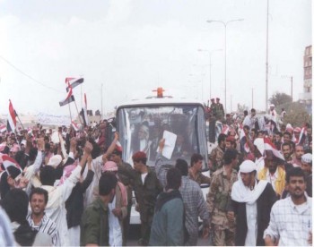 في الحافلة يرى الشيخ عبد الله وهو يحيي الجماهير التي خرجت لاستقباله أثر عودته في مارس 1998م من رحلة العلاج إلى أمريكا .